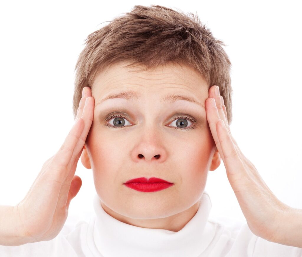 woman holding hands to head in stress