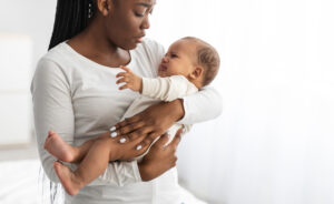 A young mother cradles her crying infant.