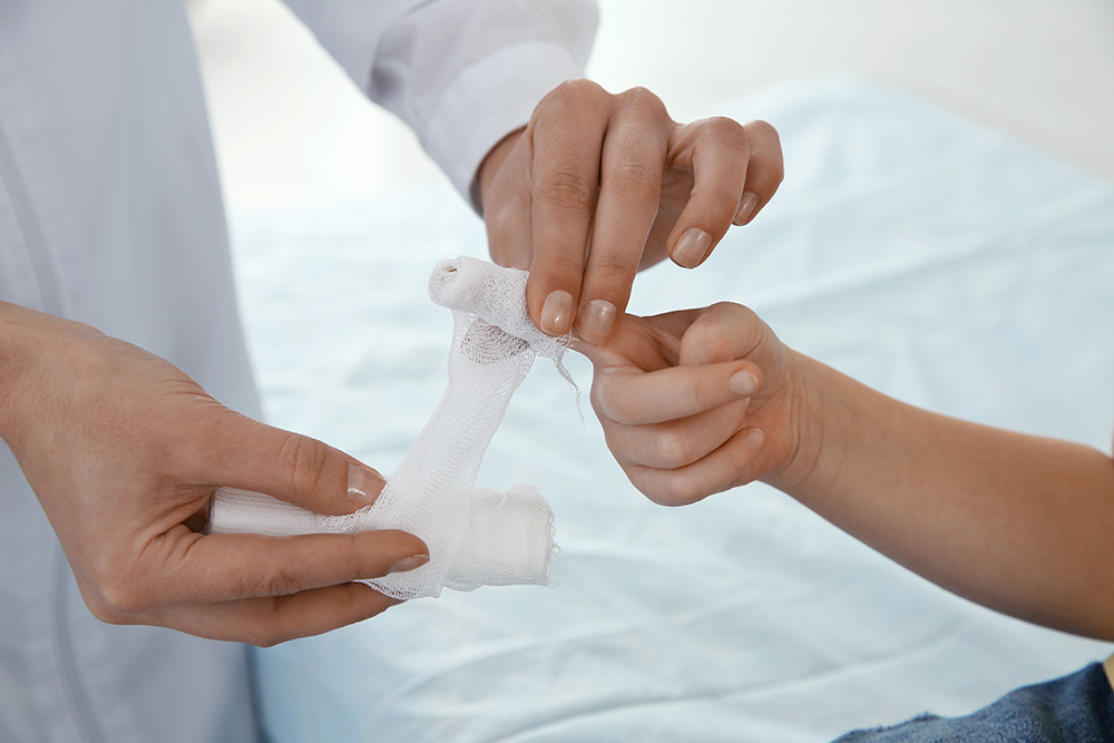 Doctor wrapping a child’s finger in gauze