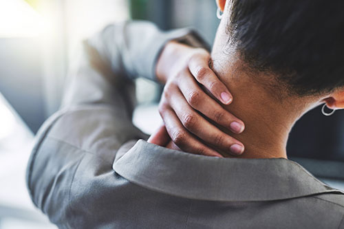 A person holds their neck in pain